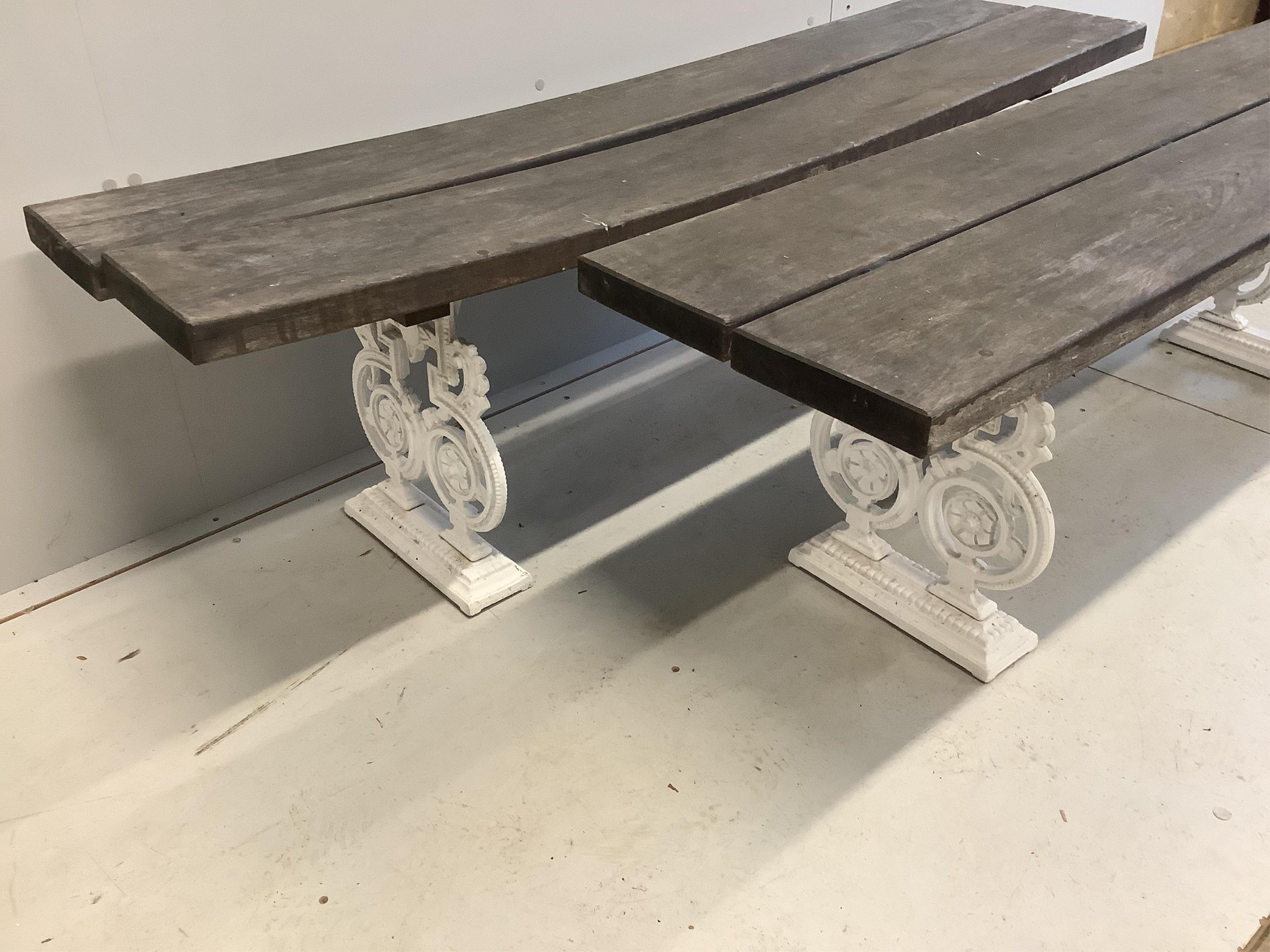 A Victorian style slatted cast metal rectangular garden table, width 151cm, depth 91cm, height 72cm, and a pair of matching benches. Condition - fair